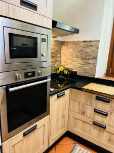una cocina con electrodomésticos de acero inoxidable y armarios de madera en Casa Maria, en Galluzzo