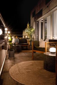 a patio at night with a couch and a table at TurnKey I Central Apartment with Terrace in Prague