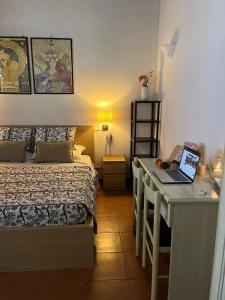a bedroom with a bed and a desk with a laptop at Villa Blu in Frascati +7 photos
