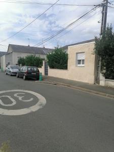 een straat met twee auto's geparkeerd naast een huis bij Studio meublée avec sanitaires douche kitchenette in Angers