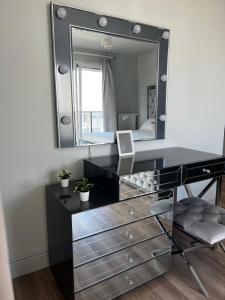 a vanity with a mirror and a desk with a laptop at Lejlighed med shoppingcenter - Beylikdüzü in Büyükçekmece