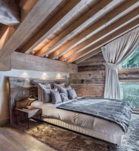 Plagne 1800にあるOdalys Chalet Sporting Lodgeの木製の天井のベッドルーム1室(大型ベッド1台付)