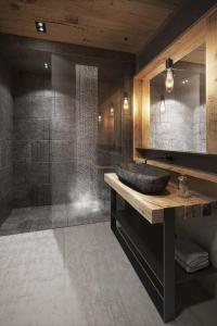 La salle de bains est pourvue d'un lavabo et d'une douche. dans l'établissement Odalys Chalet Sporting Lodge, à Plagne 1800