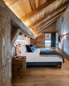 a bedroom with a large bed with wooden ceilings at Odalys Chalet Sporting Lodge in Plagne 1800