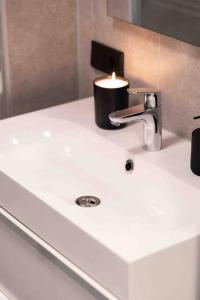 a bathroom sink with a candle on top of it at Hello Noordwijk - Appartement Duindamseweg 14E in Noordwijk