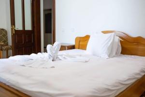 a white bed with white sheets and a bow on it at Cabana AFTER HILL in Cluj-Napoca