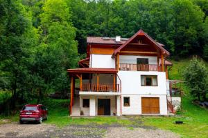 a house with a red truck parked in front of it at Cabana AFTER HILL in Cluj-Napoca