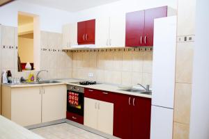 una cocina con armarios rojos y blancos y fregadero en Cabana AFTER HILL, en Cluj-Napoca