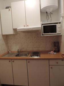 uma cozinha com armários brancos, um lavatório e um micro-ondas em Room in Brela with air conditioning, WiFi, washing machine 4947-6 em Brela