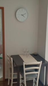 uma mesa com cadeiras e um relógio na parede em Room in Brela with air conditioning, WiFi, washing machine 4947-6 em Brela