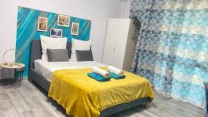 une chambre avec un lit et une table jaune avec des serviettes dans l'établissement L'ATELIEr COSY, à Cayenne 4 autres photos