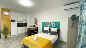 a bedroom with a large bed and a kitchen at L'ATELIEr COSY in Cayenne