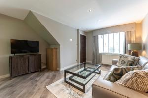 a living room with a couch and a tv at 33 Dunbar Court Gleneagles Village in Auchterarder