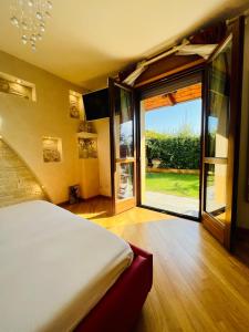 a bedroom with a bed and a large sliding glass door at Serendipity in Bentivoglio