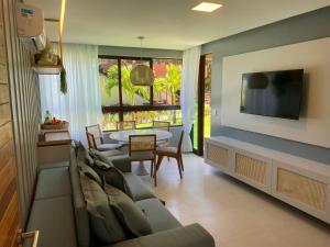 ein Wohnzimmer mit Sofa und Tisch in der Unterkunft Flat térreo luxo 2qts Carneiros ao lado da igrejinha in Tamandaré