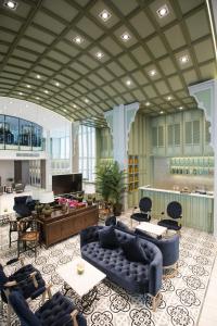 a lobby with blue couches and chairs and a bar at Hotel Tranz in Bangkok