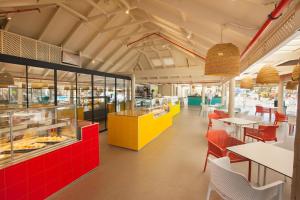 un restaurante con mesas y mostradores rojos y amarillos en Abora Continental by Lopesan Hotels, en Playa del Inglés