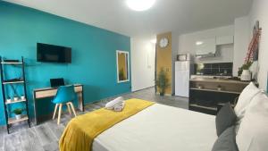 Cette chambre comprend un lit et un mur bleu. dans l'établissement L'ATELIEr COSY, à Cayenne