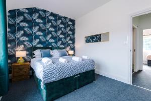 a bedroom with a large bed with a blue headboard at Lovely 4 Bed/ Monthly Discount/ Bottle in Litherland