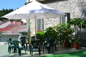 stół z krzesłami i parasol na patio w obiekcie Dom Wczasowy Zdrowie w mieście Krynica Zdrój
