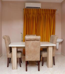 E&T Luxury Apartments في أويو: غرفة طعام مع طاولة وكراسي