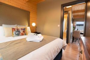 1 dormitorio con 1 cama grande con sábanas blancas y escritorio en Luxury Log Cabin with Private Hot Tub & Sea Views, en Letterkenny