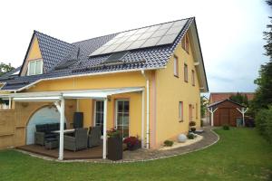 a house with solar panels on the roof at Ferienwohnung Am Helderbach in Oberheldrungen
