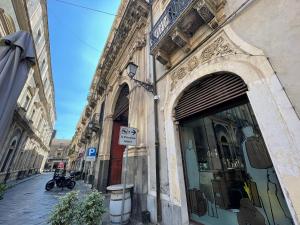 un edificio con una señal de estacionamiento frente a una tienda en Sleep Inn Catania rooms - Affittacamere, en Catania
