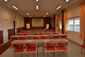 a conference room with tables and chairs and a whiteboard at Hotel Reima Country Center in Jämijärvi