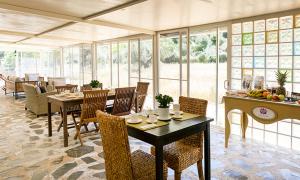 un comedor con mesas, sillas y ventanas en Paraíso Cuántico en Eslida