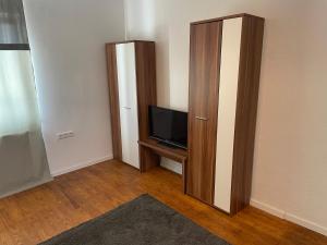 uma sala de estar com televisão e um armário em Apartament mit Schlafzimmer em Hugsweier