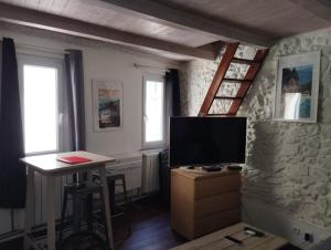 un salon avec une télévision et un bureau avec une table dans l'établissement Studio - hypercentre - WIFI et Clim, à Toulon 4 autres photos