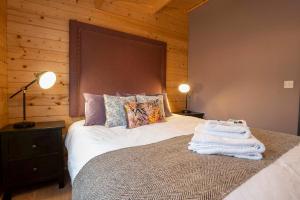 Un dormitorio con una cama con toallas blancas. en Luxury Log Cabin with Private Hot Tub & Sea Views, en Letterkenny