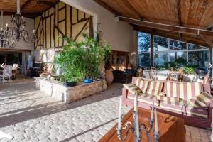 - un salon avec un canapé, des tables et des fenêtres dans l'établissement * Ancien domaine viticole de la Brandette *, à Gaillan-en-Médoc