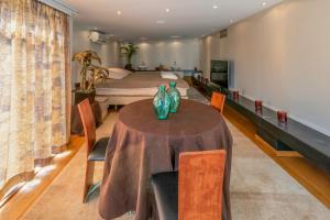 uma sala de jantar com uma mesa e uma cama em BeautyD Familie- of gezinskamer JUNIOR-SUITE centrum Gullegem em Wevelgem