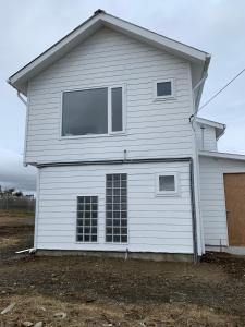 a white house with a large window at Cabañas Patagonia Encantada in Puerto Natales