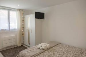 Un dormitorio con una cama con un osito de peluche. en Maison/appartement avec jardin, en Saint-Denis-en-Val