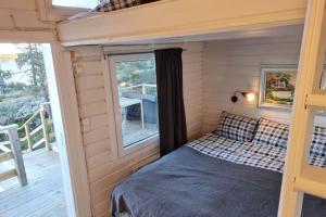 Cama en habitación pequeña con ventana en Villa Stockholms skärgård 30 min från Stockholm centralt en Tyresö