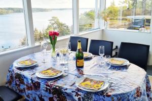 una mesa con platos de comida y una botella de vino en Villa Stockholms skärgård 30 min från Stockholm centralt en Tyresö