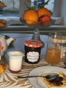 een tafel met een bord eten en een kom sinaasappels bij La maison de Céline in Arry