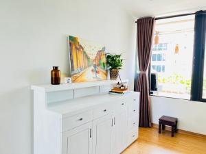 a white dresser in a room with a window at Terra Homestay - Big Balcony with elevator - 150m to Hoan Kiem Lake in Hanoi +17 photos