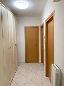 Folignano的住宿－La Casetta，走廊设有两扇门,铺有瓷砖地板
