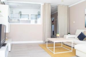Apartamento con sol de paz في توريمولينوس: غرفة معيشة مع أريكة بيضاء وطاولة