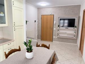 a kitchen with a table and a tv in a room at La Casetta in Folignano