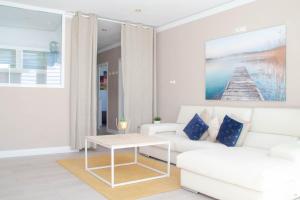 sala de estar con sofá blanco y mesa en Apartamento con sol de paz, en Torremolinos