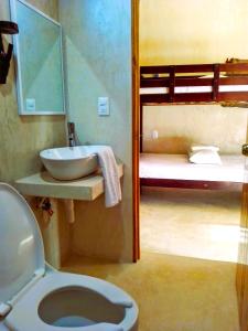 a bathroom with a toilet and a sink and bunk beds at Tribe Beachville in El Cuyo