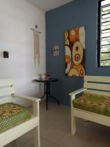 Pokój z dwoma łóżkami, stołem i obrazem w obiekcie Villa Margaritas w mieście Bacalar