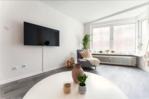 a living room with a tv and a table at Stay Awesome - Apartment Philosophenweg, Netflix and Disney in Kassel