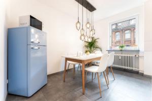 a kitchen with a table and a refrigerator at Stay Awesome - Apartment Philosophenweg, Netflix and Disney in Kassel