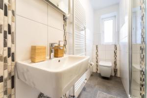 a white bathroom with a sink and a toilet at Stay Awesome - Apartment Philosophenweg, Netflix and Disney in Kassel